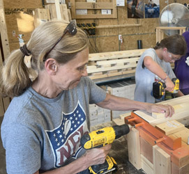 Two volunteers operate drills