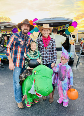 costumed family, child riding a dinosaur